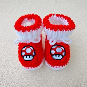 Super Mario Red Pilz-inspirierte gestrickte Babyschühchen * Neugeborene bleiben auf Krippe Schuhe * Gamer Geschenk * Geschlecht offenbaren Geschenk * Baby-Hausschuhe