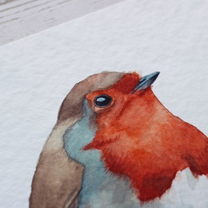 A close up of a watercolour print of a robin