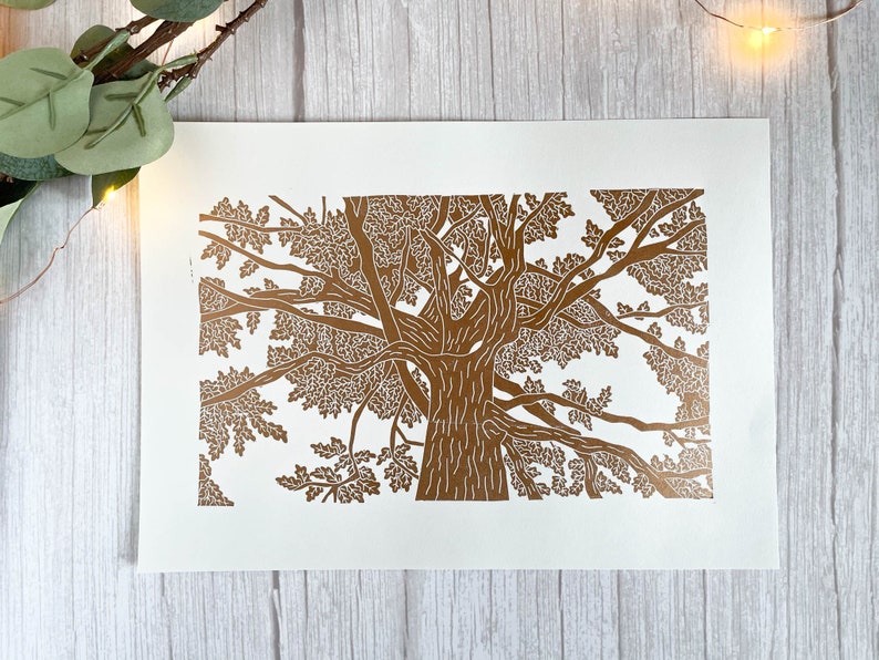 A copper lino print of an oak tree. The perspective is from standing underneath the tree looking up to the top of it.
