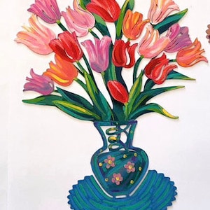 May include: A bouquet of colorful tulips in a blue and white vase with a floral pattern. The vase is sitting on a blue and white patterned base.