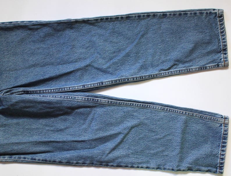 May include: A pair of blue denim jeans with a straight leg and a classic fit.
