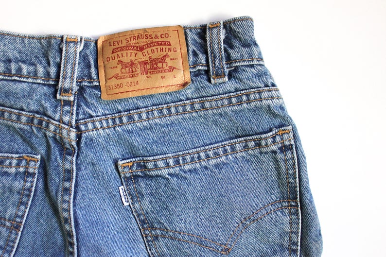 May include: A pair of blue denim jeans with a brown leather patch that reads "Levi Strauss & Co. Original Riveted Quality Clothing" and the number "31350-0214".
