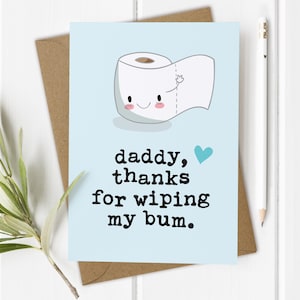 May include: A light blue card with a cartoon toilet paper roll with a smiling face and a heart. The text on the card reads "daddy, thanks for wiping my bum."
