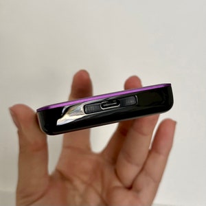 May include: A black and purple external hard drive with a USB-C port and a small LED light.