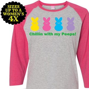 May include: A pink and grey baseball tee shirt with a graphic of four colorful Peeps and the text "Chillin with my Peeps!"