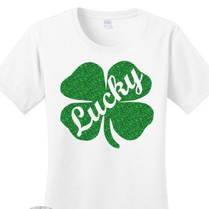 グリーングリッターの幸運の四つ葉のクローバー、シャムロック、セントパトリックスデーのレディースTシャツ。7色展開。サイズはS～4X、プラスサイズ。