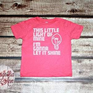 May include: Pink toddler t-shirt with a white lightbulb graphic and the text "This little light of mine I'm gonna let it shine".