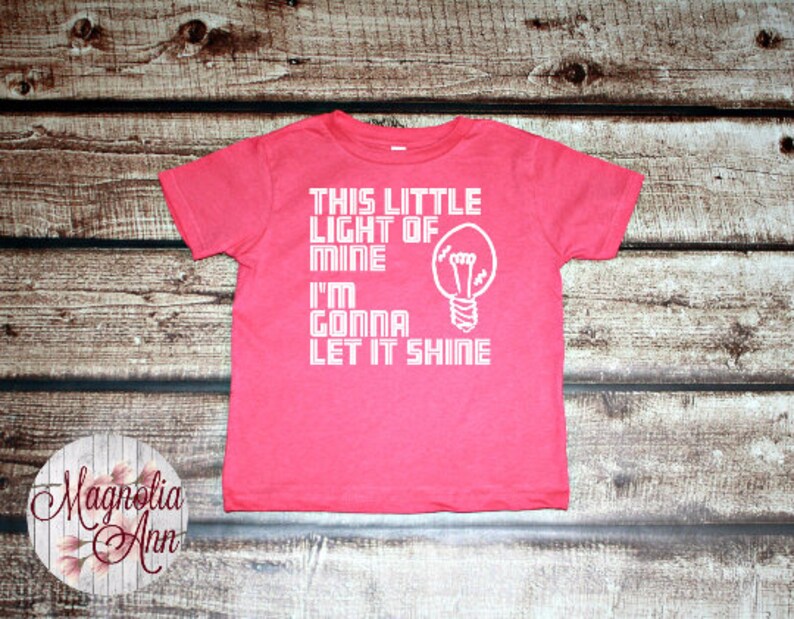 May include: Pink toddler t-shirt with a white lightbulb graphic and the text "This little light of mine I'm gonna let it shine".