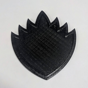 May include: A black 3D printed design in the shape of a stylized flame.