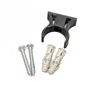 May include: A black plastic wall mount with two screws and two plastic anchors. The wall mount is designed to hold a pipe or other round object.