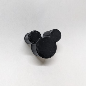 May include: A black plastic Mickey Mouse head shaped wall hook.