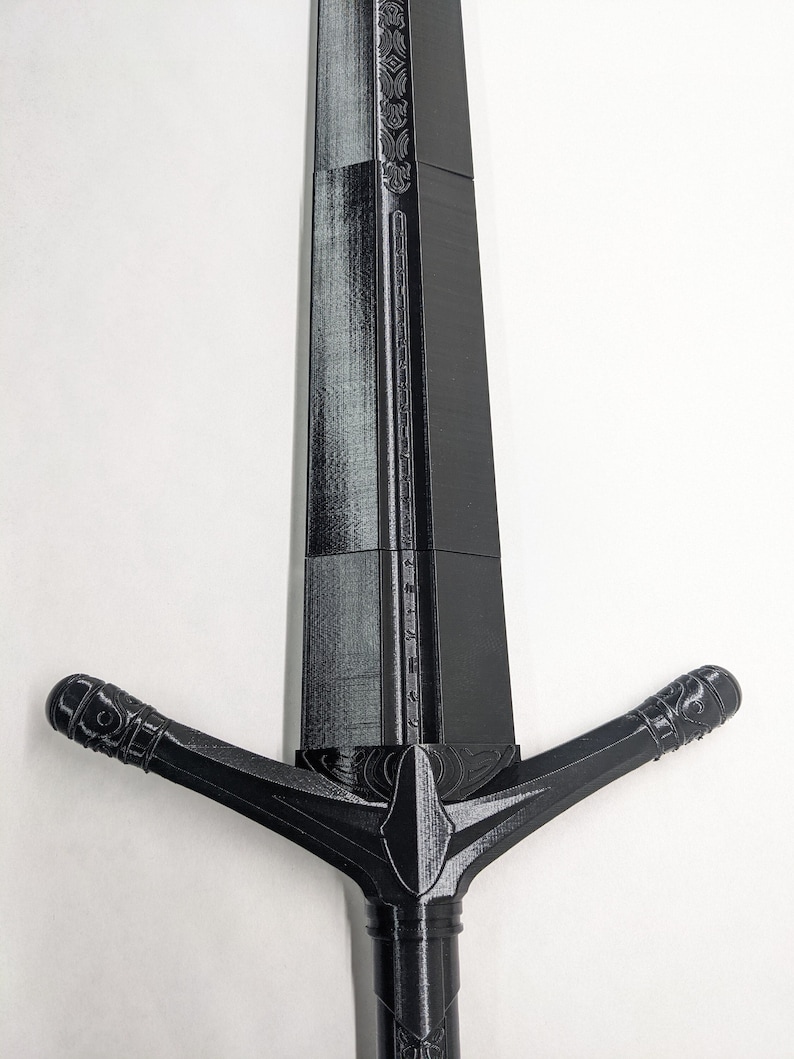 K&ouml;nnte beinhalten: Ein schwarzes, im 3D-Druck hergestelltes Schwert mit einem dekorativen Griff und einer langen, geraden Klinge.