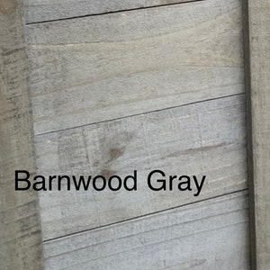 May include: Close-up of a weathered, gray wooden surface with horizontal planks. The text "Barnwood Gray" is displayed in a black font, adding a descriptive element to the image. The wood grain texture is visible.
