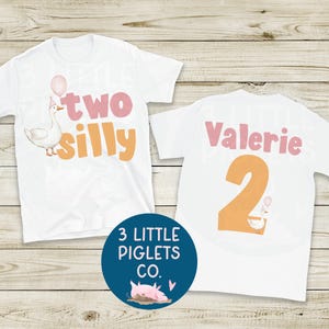 May include: White t-shirts with a whimsical design. One shirt features a goose with the words "two silly" and a balloon. The other shirt has the name "Valerie" and the number "2". A blue circle with a pig graphic is also visible.