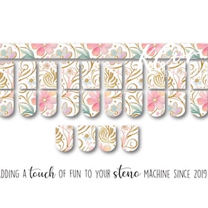 May include: A set of adhesive nail wraps featuring a floral pattern with pink flowers, green leaves, and gold swirling accents. The design includes various rectangular strips with rounded ends and the text: ADDING A TOUCH OF FUN TO YOUR STENO MACHINE SINCE 2019.