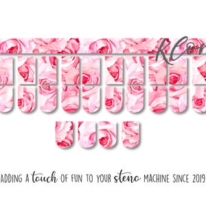 May include: A set of steno machine key covers with a watercolor rose design in shades of pink and red. The covers are arranged on a white background. Text at the bottom reads, "Adding a touch of fun to your steno machine since 2019."