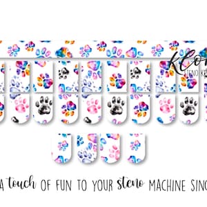 May include: Steno machine key stickers with colourful paw prints in a watercolour style. The stickers feature paw print designs in shades of blue, pink, and black. Text reads "Adding a touch of fun to your steno machine since 2019."
