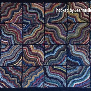 May include: Hand-hooked rug with a repeating pattern of wavy, colorful lines in shades of blue, brown, red, and gold. The rug is made up of square blocks, each with a unique design. The text "hooked by Jeanne Howison" is visible.