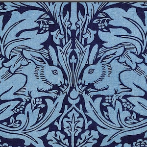 May include: A repeating pattern in shades of blue featuring two rabbits facing each other, surrounded by stylized leaves and floral elements. The design has a vintage, botanical feel, with a detailed, symmetrical layout.