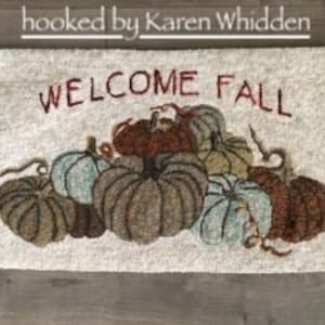 Peut inclure: Un paillasson beige avec le texte "WELCOME FALL" brodé en rouge. Le paillasson présente un motif de plusieurs citrouilles dans différentes nuances de brun, vert et bleu.