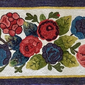 May include: A rug with a floral design featuring red, blue, and green flowers on a white background. The rug has a yellow border and a dark blue outer border.