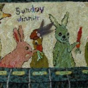 May include: A colorful, textured rug featuring whimsical animal characters. A pink bunny, a green bunny holding a carrot, and a bird are depicted. The words "Sunday dinner" are embroidered above the characters. The rug has a blue and green border.