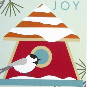 May include: A red birdhouse with a white snow-covered roof and a blue circle opening. The word "JOY" is written in blue letters on a light blue background. A small gray bird with a black head is perched on the edge of the birdhouse.