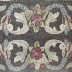May include: Rectangular rug with a dark brown background and a symmetrical floral design. The design features light green and cream-colored leaves, red and pink flowers, and blue accents. The rug is likely made of wool or a similar material.