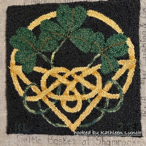 May include: A black and gold rug with a Celtic knot design and green shamrock leaves. The rug is hooked by Kathleen Lynch.
