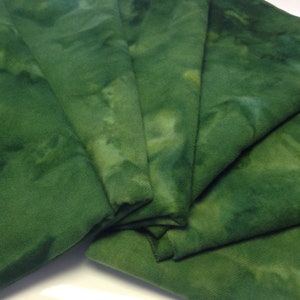 May include: A stack of five green fabric squares with a tie-dye pattern. The fabric has a soft, textured feel.