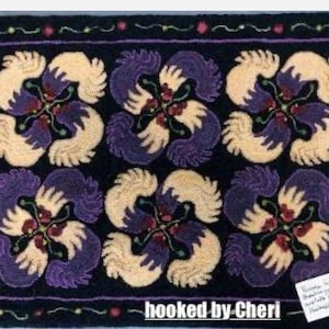 May include: A handmade rug featuring a repeating floral design in cream, purple, and red on a black backdrop. The rug has a black border with decorative trim. The text "hooked by Cheri" is visible in the lower right corner.