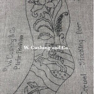 May include: A gray linen fabric with a black outline of a Christmas stocking design. The design includes floral and leaf patterns, with text that reads "W. Cushing & Co." and "Crewel Stocking Deer". The stocking measures 23x9 inches.