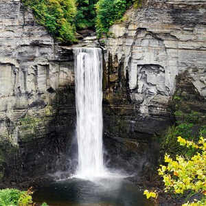 Peut inclure: Une puissante cascade se pr&eacute;cipite d'une falaise rocheuse, cr&eacute;ant une brume vaporeuse. Une v&eacute;g&eacute;tation luxuriante entoure le pied de la cascade, ajoutant &agrave; la beaut&eacute; naturelle de la sc&egrave;ne.