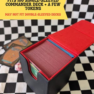 May include: Black and red card deck box, open to reveal a stack of cards. The box is labeled to fit 100 single-sleeved Commander decks and a few tokens. The background is a black and white checkered pattern.