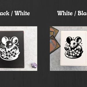 May include: Black and white card holder featuring a mouse illustration with flowers. The text "Black / White" and "White / Black" is displayed above the card holders. The card holders are on a light gray surface.
