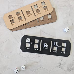 May include: Two wooden scoreboards with slots for dice, labeled "P1", "P2", "TURN", "VP*" and "CP". A black scoreboard with the same labels is shown with dice in the slots.