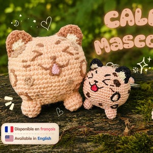 Peut inclure: Deux figurines de chat au crochet, rondes et de couleur pêche, avec des taches brunes, des visages brodés et des langues roses. La plus grande est une peluche, la plus petite un porte-clés. Texte : CALEB MASCOTTE, Patron PDF, Disponible en français.
