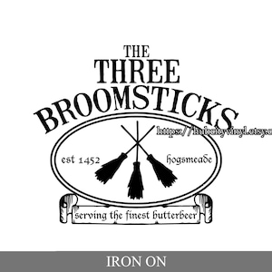 May include: Black and white iron-on design for The Three Broomsticks, a fictional pub from the Harry Potter series. The design includes the pub's name, the text "est 1452", "Hogsmeade", and "serving the finest butterbeer". It also features three crossed broomsticks.