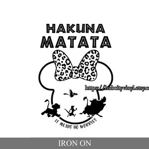 Op de afbeelding: Zwart-witte strijkfolie met de tekst "Hakuna Matata", een strik met luipaardprint, Mickey Mouse-oren en een silhouet van Simba, Timon en Pumbaa. De tekst "It means no worries" staat onder de figuren.