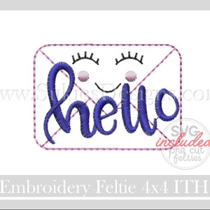 May include: A blue embroidered "hello" design with eyelashes and a smile, inside a pink rectangular frame. The design includes the text "SVG included one cut felties" and "Embroidery Feltie 4x4 ITH".