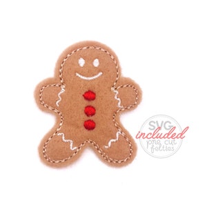 May include: A brown gingerbread man felt applique with white stitching and red buttons. The applique is perfect for adding a festive touch to crafts and projects.