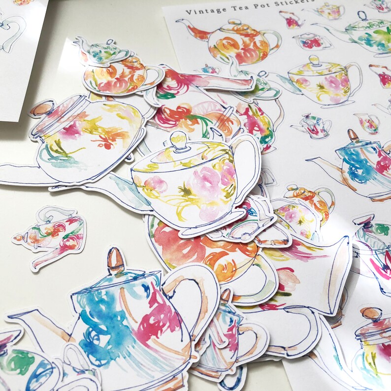 May include: A set of vintage tea pot stickers featuring watercolor illustrations of teapots with floral patterns in shades of pink, blue, yellow, and green. The stickers are perfect for adding a touch of vintage charm to your home decor.
