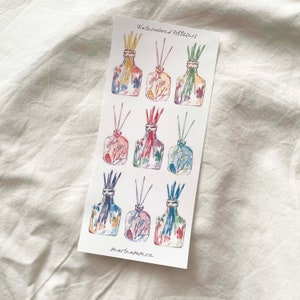 May include: A sheet of watercolor stickers featuring nine different designs of glass bottles with colorful floral patterns and sticks inside. The text "Watercolored Diffusers" and "Pearteapaperie" are printed on the sheet.