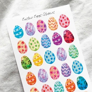 May include: A sheet of Easter egg stickers with various colorful designs. The eggs feature patterns like hearts, polka dots, and zigzags in shades of blue, pink, yellow, and green. The text "Easter Eggs Stickers" is written at the top.