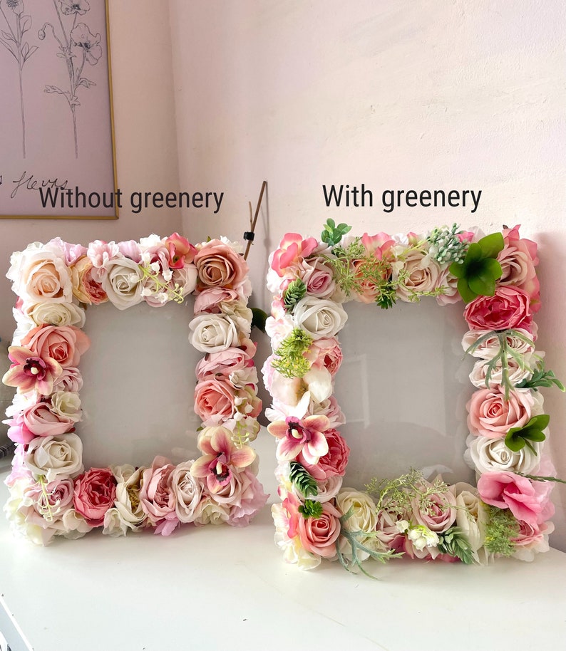May include: Two picture frames decorated with pink and white artificial flowers. The frame on the left has no greenery, while the frame on the right has green leaves and stems. Both frames say "Without greenery" and "With greenery" respectively.