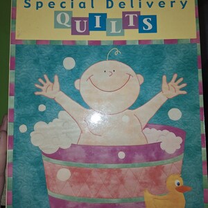 May include: A book cover with a colorful illustration of a baby in a bathtub with a rubber ducky. The title of the book is "Patrick Lose's Special Delivery Quilts".