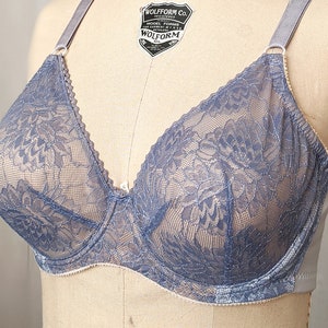 Może przedstawiać: Niebieski biustonosz z koronki z kwiatowym wzorem. Biustonosz ma regulowane ramiączka i zapięcie na haftki z tyłu.