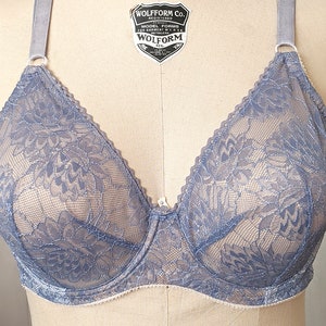 Może przedstawiać: Niebieski biustonosz z koronki z kwiatowym haftem i regulowanymi ramiączkami. Biustonosz zapinany z tyłu na haftki.