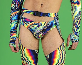 Puede incluir: Un vibrante conjunto con estampado psicodélico que incluye un top corto de manga larga, calzoncillos con cinturón y leggings hasta el muslo. El diseño colorido incluye tonos de azul, amarillo, verde y rojo. El modelo lleva botas de plataforma negras. El fondo es verde liso.