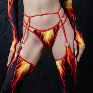Può includere: Un completo coordinato con un design a fiamma. Il set include un top all'americana, biancheria intima, manicotti e pantaloni a zampa. Le fiamme sono rosse, gialle e arancioni su sfondo nero.